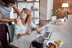 Young adult couple laughing and watching at each other while working. casual business concept