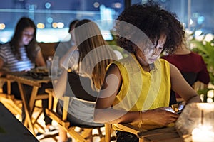 Young adult on a dinner date using a smartphone addiction concep