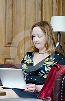 Young adult early 40s businesswoman, manager, working on tablet