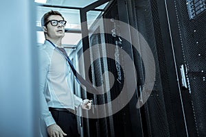 Young adult in eyeglasses standing in the corridor