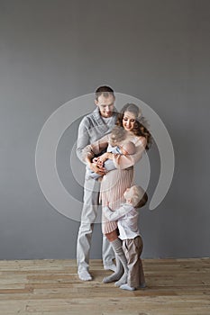 Young adult family with an infant and a child in a studio