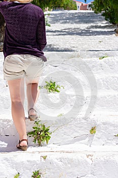 Young adult female walking up the white stairs