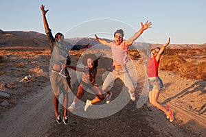 Young adult friends having fun jumping in the desert