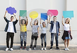 Young adult friends holding up copyspace placard thought bubbles