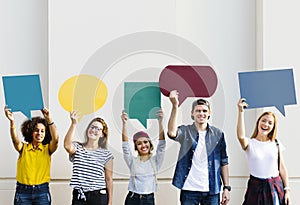 Young adult friends holding up copyspace placard thought bubbles