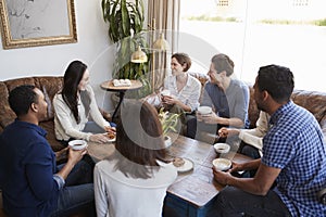 Young adult friends talking around a table at a coffee shop