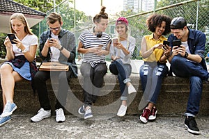 Young adult friends using smartphones together