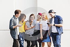 Young adult friends using smartphones together outdoors youth cu