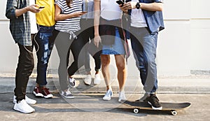 Young adult friends using smartphones together outdoors youth cu