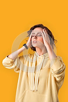 Young adult girl with closed eyes touching her head