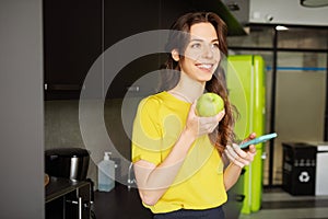 Young adult girl with smartphone and apple.