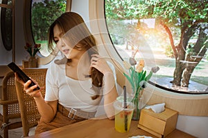 Young adult happy asian woman using smart phone for social media application, shopping online, transfer money, financial, message