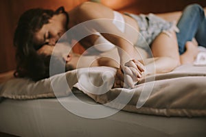 Young adult heterosexual couple lying on bed in bedroom photo