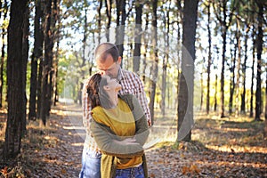 Young adult love couple walking in forest, young family outdoor, husband kiss his wife in hairs