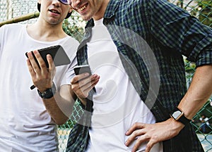 Young adult male friends on the basketball court using smartphones millennials concept photo