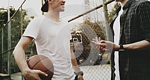 Young adult male friends playing basketball in the park