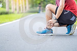 Young adult male with his muscle pain during running. runner man having leg ache due to Ankle Sprains or Achilles Tendonitis. photo