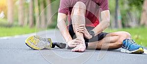 Young adult male with his muscle pain during running. runner man having leg ache due to Ankle Sprains or Achilles Tendonitis. photo