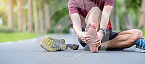 Young adult male with his muscle pain during running. runner man having leg ache due to Plantar fasciitis. Sports injuries and photo