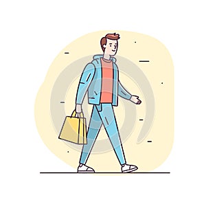 Young adult male walking casually carrying shopping bag, dressed light blue jacket, orange hoodie photo