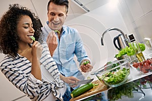 Young adult man and african american woman cooking healthy food together