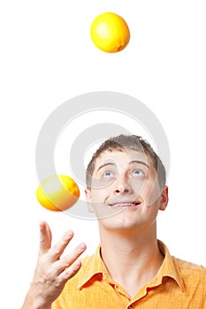 Young adult man juggle with oranges