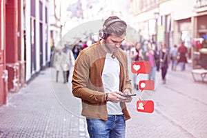 Young Adult Man Listening Music on Smartphone and Headphone on The Street at Summer Time