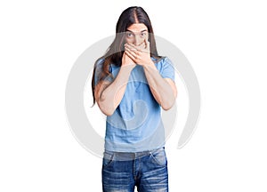 Young adult man with long hair wearing casual clothes shocked covering mouth with hands for mistake