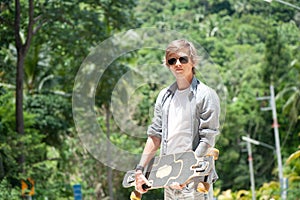 Young adult man with skate board on the road