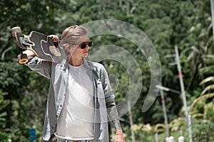 Young adult man with skate board on the road