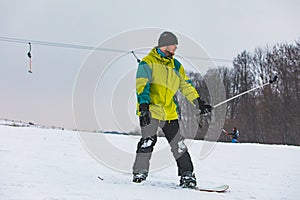 young adult man snowboarding and taking selfie on action camera