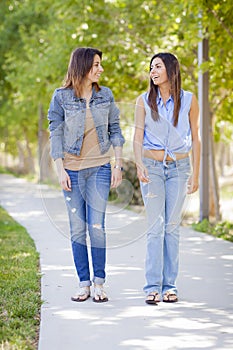 Young Adult Mixed Race Twin Sisters Walking Together