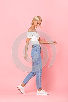 Young adult model in denim clothes and white sneakers