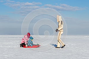 Young adult mother wear warm jacket enjoy have fun sledging two cute little sibling kids boy girl at frozen white snow