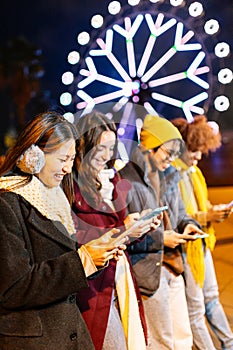 Young adult people using smartphones outdoors in winter day