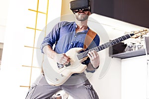 Young adult playing guitar at home using viewer