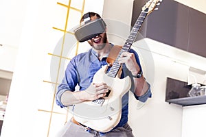 Young adult playing guitar at home using viewer