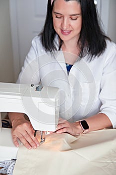 Young adult seamstress working on sewing machine