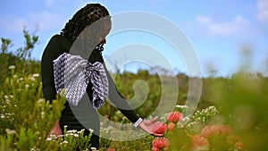 Young adult seen admiring flowers in nature