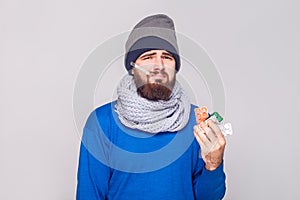 Young adult sick man have temperature, holding many pills.