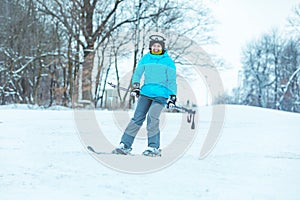 young adult smiling woman skiing down by hill