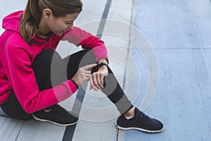 Young adult sportswoman  using smart watch technology on training