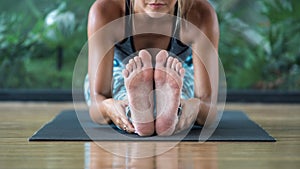 Young adult sporty girl making yoga exercise in fitness class