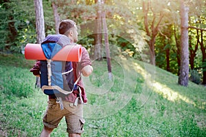 Young adult traveler walking in a forest for a trip