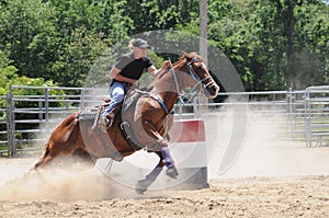 Young adult woman barrel racing