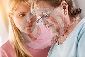 Young Adult Woman Consoles Sad Senior Adult Female photo