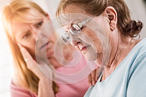 Young Adult Woman Consoles Sad Senior Adult Female photo