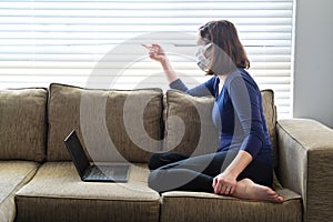 Young adult woman diagnosed as infected in Coronavirus in a self home isolation lock down quarantine looking outside a window