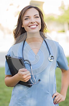 Young Adult Woman Doctor or Nurse Holding Touch Pad Outside