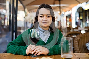 Young adult woman drinking wine at restaurant